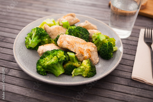 Pieces of fried chicken breast with boiled broccoli on plate for breakfast