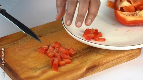 young female hand cutting bell pepper with knife, closeup
