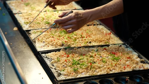 屋台で職人がたこ焼きを焼く映像