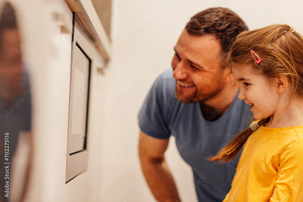 Young dad is cooking together with his cute daughter in the kitchen at home Young dad is cooking together with his cute daughter in the kitchen at home