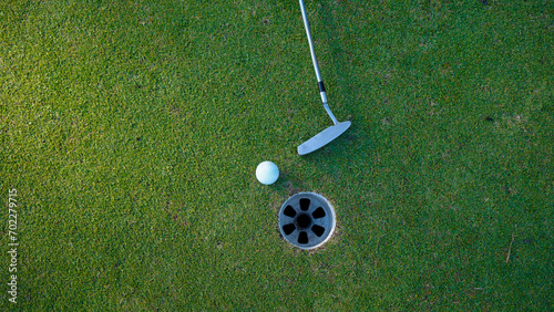 white golf ball in hole on green grass good for background with sunlight.