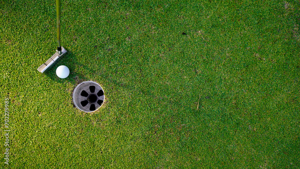 Obraz premium white golf ball in hole on green grass good for background with sunlight.