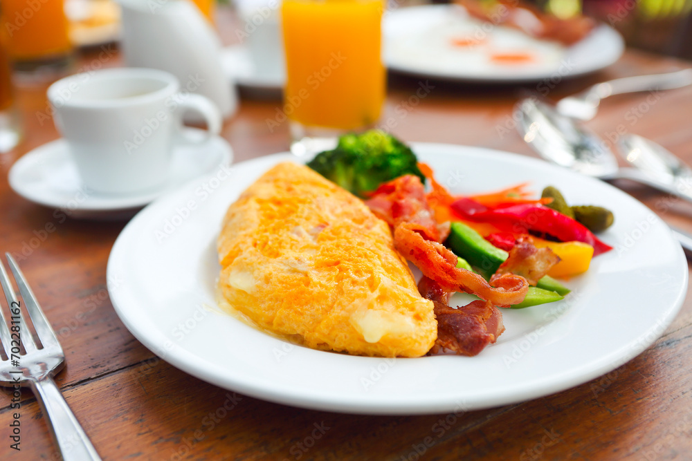Omelet with pepper, cucumber, bakon and salad on the table