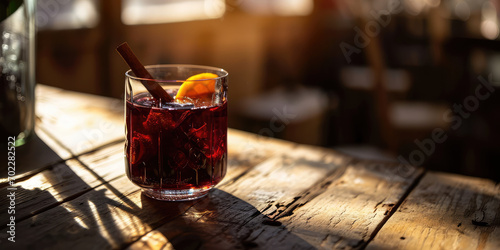 Close-up of Mulled wine in a beautiful glass with a cinnamon stick, sunny. A traditional winter Christmas alcoholic cocktail, warming gluhwein. 