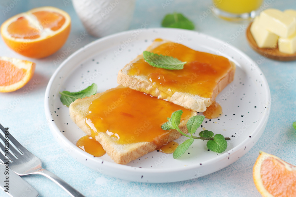 Fototapeta premium Sandwiches with marmalade, orange juice and coffee ready for breakfast