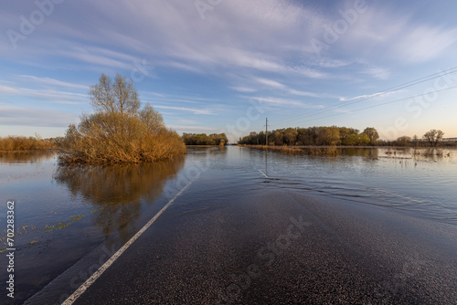 Flooded road after river flood, spring flood. © Sergei