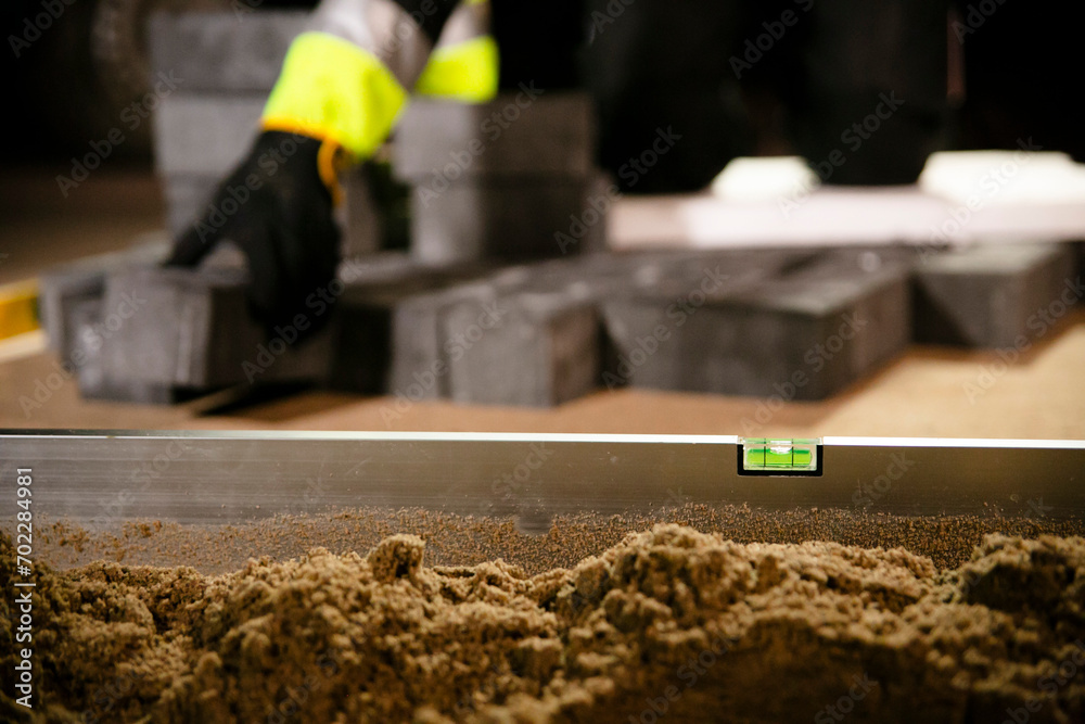 Wasserwaage vor Pflasterer