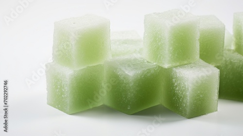 oneydew melon cubes on a pristine white surface, highlighting the light green and refreshing texture of this melon.