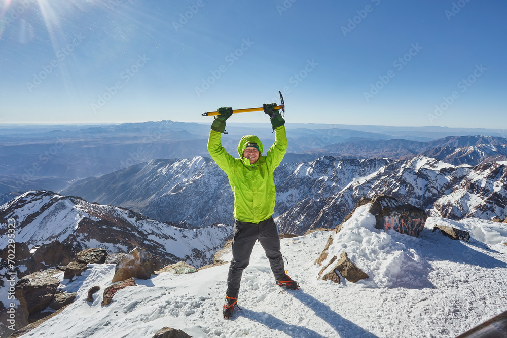 Climber or alpinist at the top of a mountain. A success of mountaineer