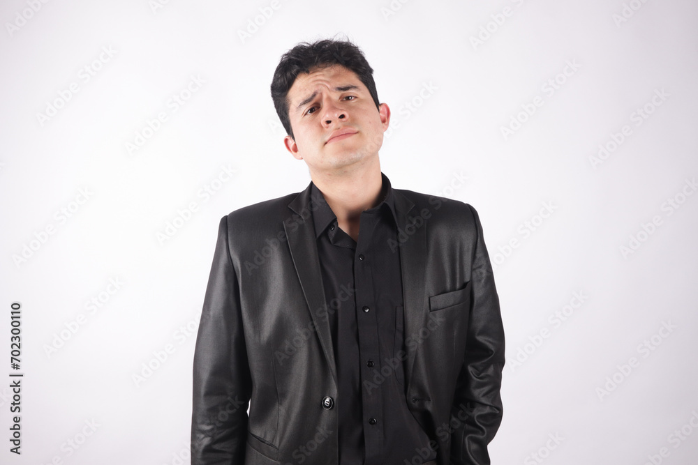 Photograph of young man in black elegant jacket, with a gesture of displeasure and white background. Concept of people and emotions. Photograph of young man in black elegant jacket, with a gesture of displeasure and white background. Concept of people and emotions.