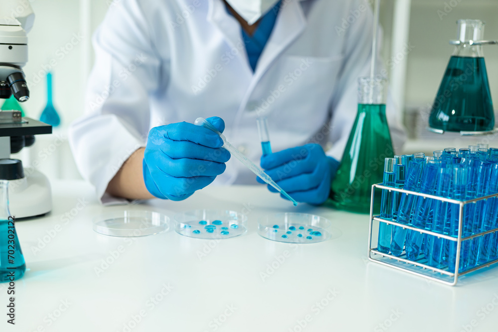 Laboratory concept: Close-up of chemicals in a laboratory, a biochemist is conducting experiments in a controlled environment in a laboratory. Doctor wearing gloves holding a test tube Laboratory concept: Close-up of chemicals in a laboratory, a biochemist is conducting experiments in a controlled environment in a laboratory. Doctor wearing gloves holding a test tube