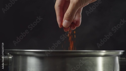 Chef's Hand Adding Paprika, Red Chili Powder In The Soup Pot. Sukiyaki Or Shabu
 photo