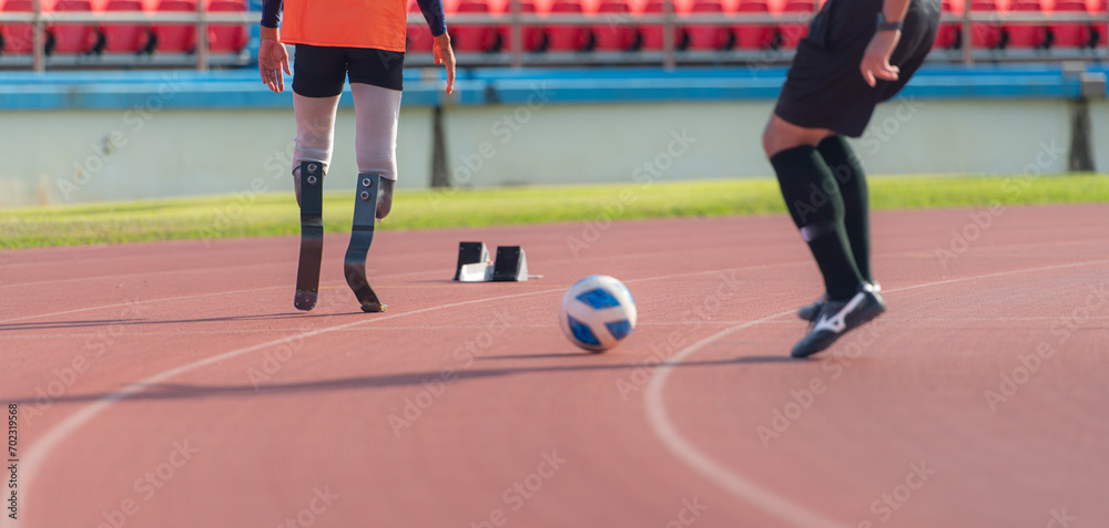 Soccer player kicking the ball on the track in the stadium with disabled athletes training sessions.