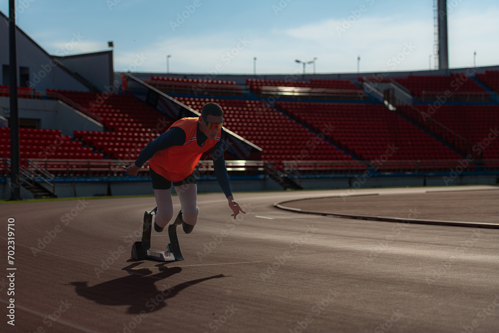 Fototapeta premium Disabled athletes prepare in starting position ready to run on stadium track