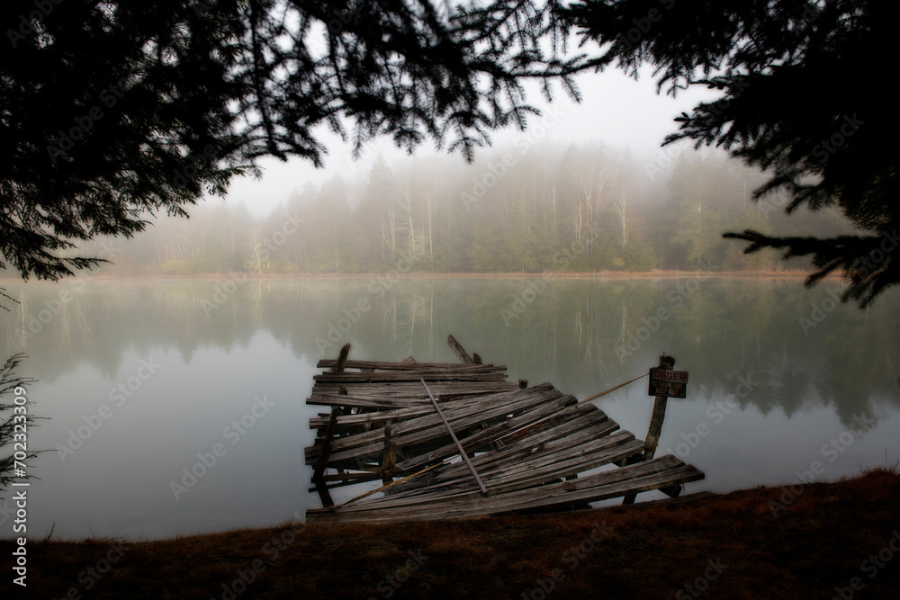 Old dock on lake in the fog