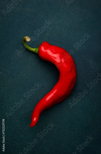 Fototapeta Naklejka Na Ścianę i Meble -  Red chili pepper on deep green background, minimalistic style, top view
