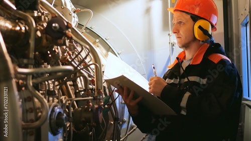 Industrial worker inspects turbine pre-engine start in industrial setting. Showcases industrial workers focus on safety, efficiency. Ideal for highlighting an industrial workers expertise.