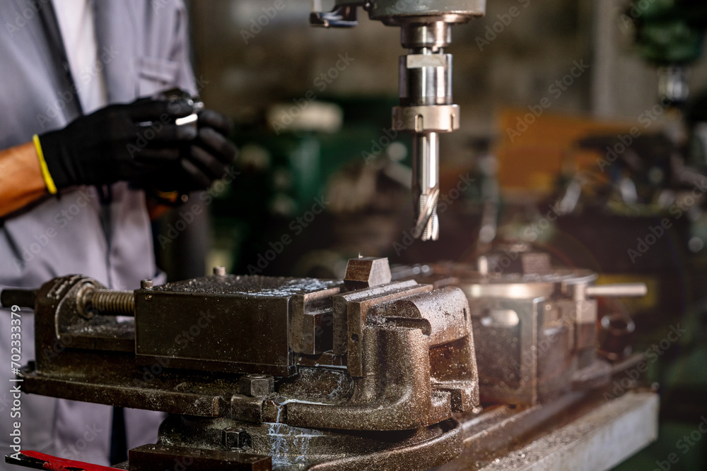 Engineer worker in production plant drilling at machine. Professional worker near drilling machine on factory. man inspecting and repairing machine for operation in workshop.