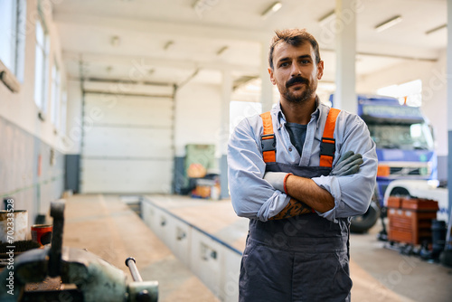 Portrait of truck repair shop owner with arms crossed looking at camera. photo
