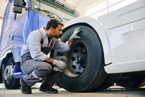 Εκτύπωση καμβά Truck maintenance mechanic inspecting tires of vehicle in workshop