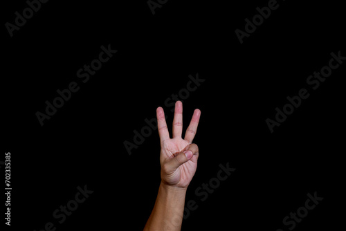 A hand isolated on black background. American sign language alphabet W.