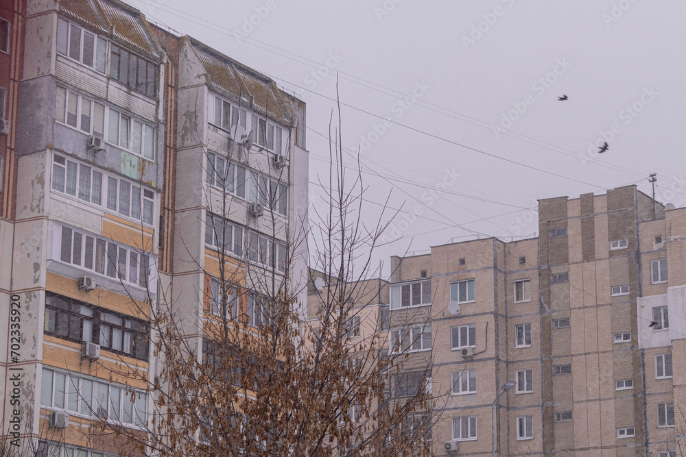 Kyiv, Ukraine - January 3, 2024: there are many snow-covered cars in the yard among the houses. It is snowing in the city. Kyiv, Ukraine - January 3, 2024: there are many snow-covered cars in the yard among the houses. It is snowing in the city.