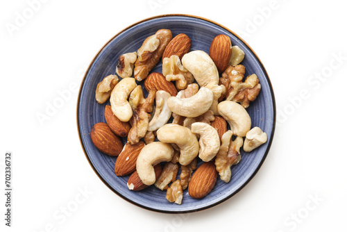 Peeled walnuts isolated on white. Tapas nuts serving. Blue plate with nuts. Pile of cashew nuts. Healthy snack portion. Closeup macro almonds structure.