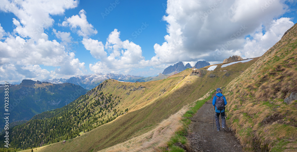 hiker at trail to Pordoijoch, alpine landscape south tyrol, dolomites