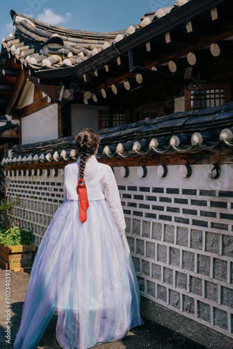 Tourist girl wearing traditional korean hanbok at the Gyeongbokgung Palace in Seoul, South Korea.