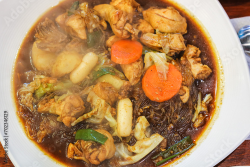 Jjimdak Korean Soy Braised Chicken. Popular Korean braised chicken originating in the city of Andong, Korea. Carrots, soy sauce, potatoes, tteok, cabbage and vermicelli.