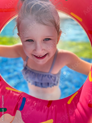 Baby girl smiling in swimming pool. Child having fun in swimming pool (ID: 702349941)