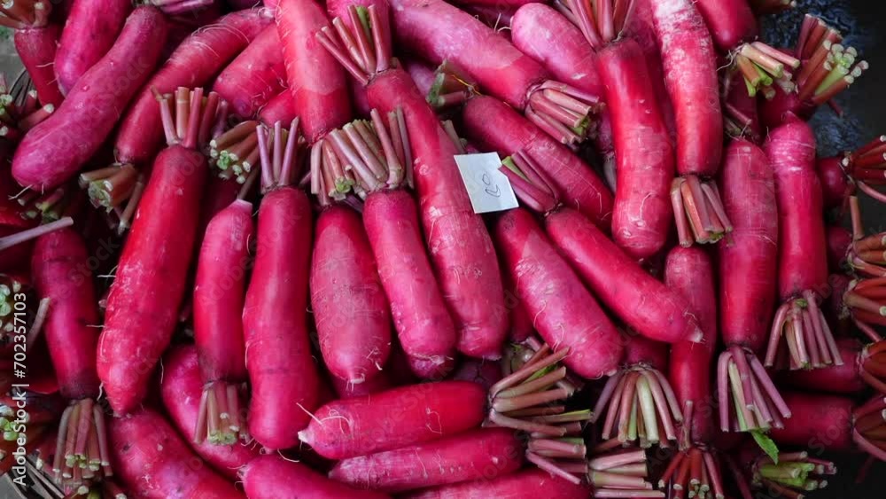 Organic long scarlet red radishes arranged in bamboo baskets are kept for sale. Organic long scarlet red radishes arranged in bamboo baskets are kept for sale.