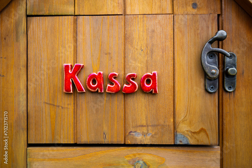 Small wood plank door with word Kassa. Self service.