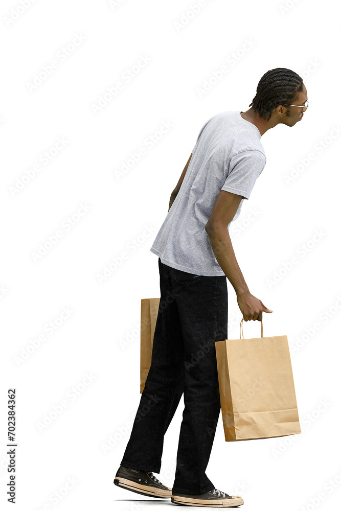 A man in a gray T-shirt, on a white background, full-length, with bags