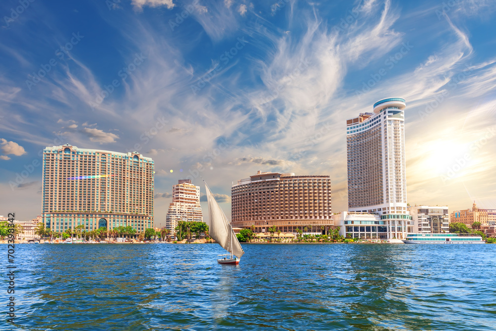 Nile river with a boat by the luxurious buildings of modern Cairo, Egypt