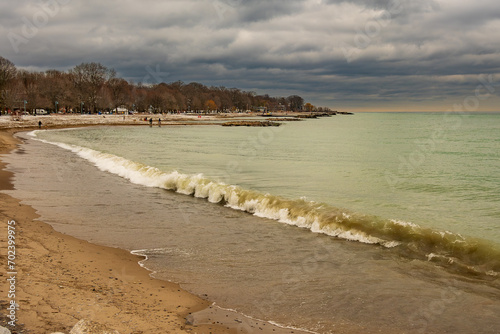 Photography waves breaking on a sandy  beach with dramatic clouds shot at kew beach toronto