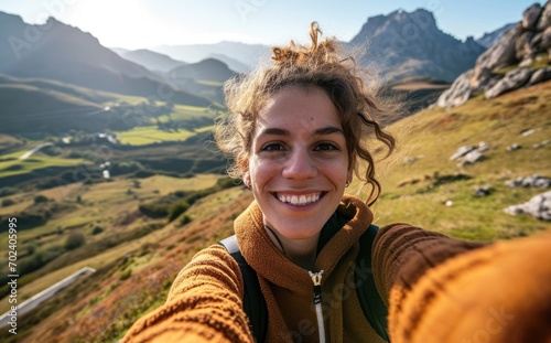  In the Cordillera Cantabrica of Spain, a smiling native woman with a backpack takes a selfie near Picos de Europa, portraying the joy and cultural richness of her travel adventure photo