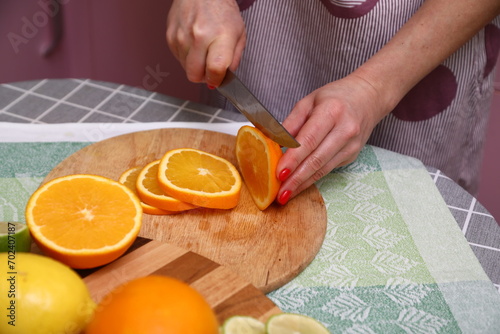 A person cutting oranges on a cutting board