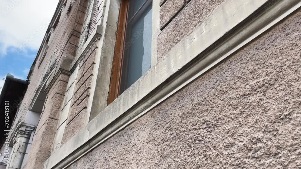 Walking by a facade of a building with windows Walking by a facade of a building with windows