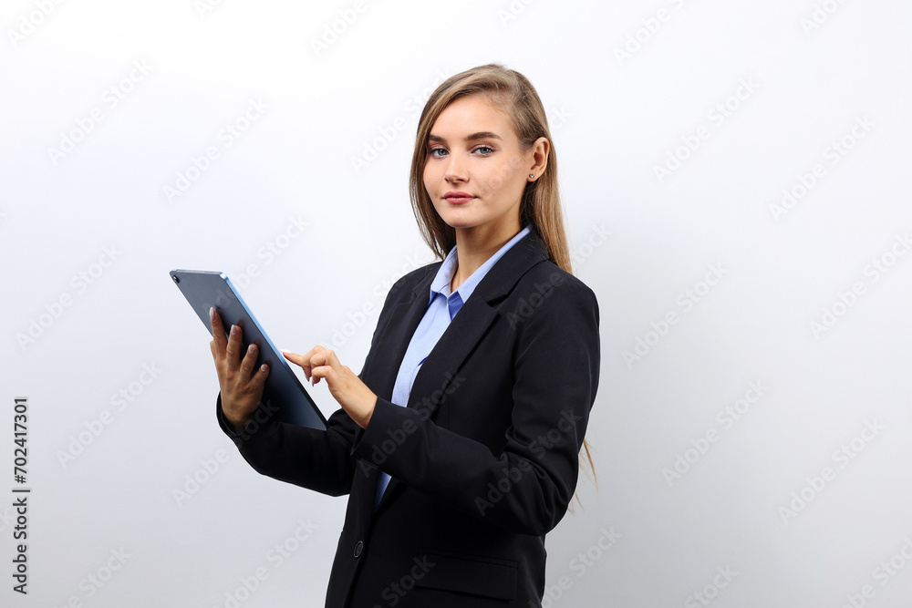 Young business woman checking email on a tablet while standing on a clean background with copy space Young business woman checking email on a tablet while standing on a clean background with copy space