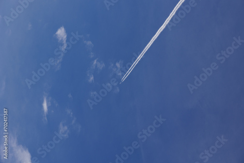 Konstfotografi Aereo di linea che viaggia nel cielo azzurro e sereno, visto dal basso mentre la