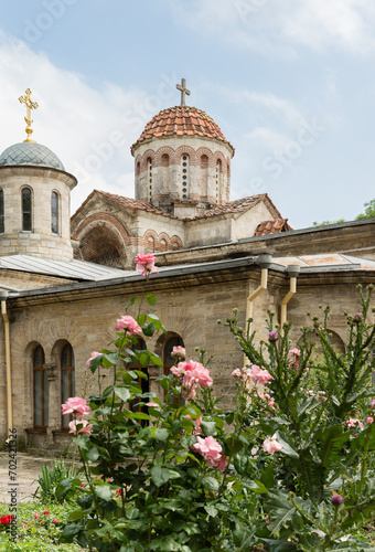 Blooming roses near the ancient Cathedral of St. John Baptist, an Orthodox church in the center of Kerch, the oldest operating temple in the Crimea