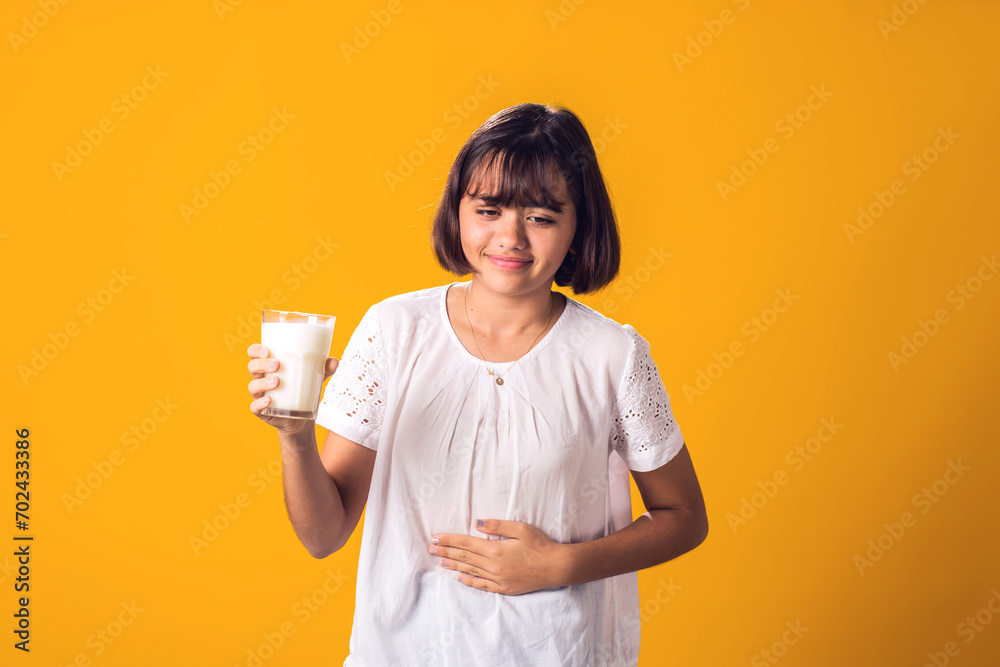 Girl with glass of milk feeling stomach pain. Dairy Intolerant person. Lactose intolerance, health care concept. Girl with glass of milk feeling stomach pain. Dairy Intolerant person. Lactose intolerance, health care concept.