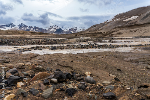River flowing through The Valley of Ten Thousand Smokes in Katmai National Park and Preserve in Alaska. Valley between mountains is filled with ash flow from Novarupta eruption in 1912. Erosion of ash