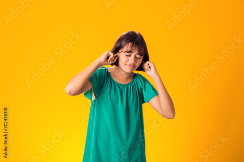 Girl ignoring stressful environment, closed ears with hands