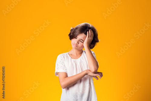 Sad kid girl over yellow background. Frustration concept