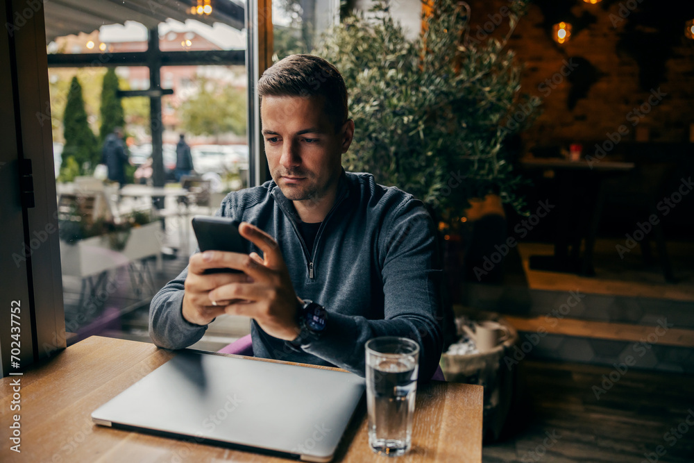 A man sitting in coffee shop and using his phone. A man sitting in coffee shop and using his phone.