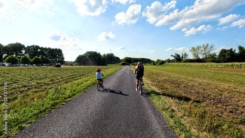 Dad and son on a bike trip. Back view. Summer in Poland.