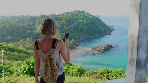 Tourist woman taking photos with mobile phone. Beautiful tropical landscape. Thailand, Asia.