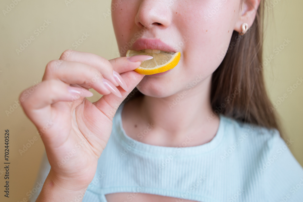 young beautiful girl eating lemon, close-up, crop photo. mouth eating a slice of lemon young beautiful girl eating lemon, close-up, crop photo. mouth eating a slice of lemon